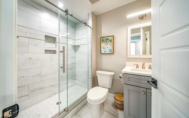 a bathroom with a granite countertop toilet a sink and a shower