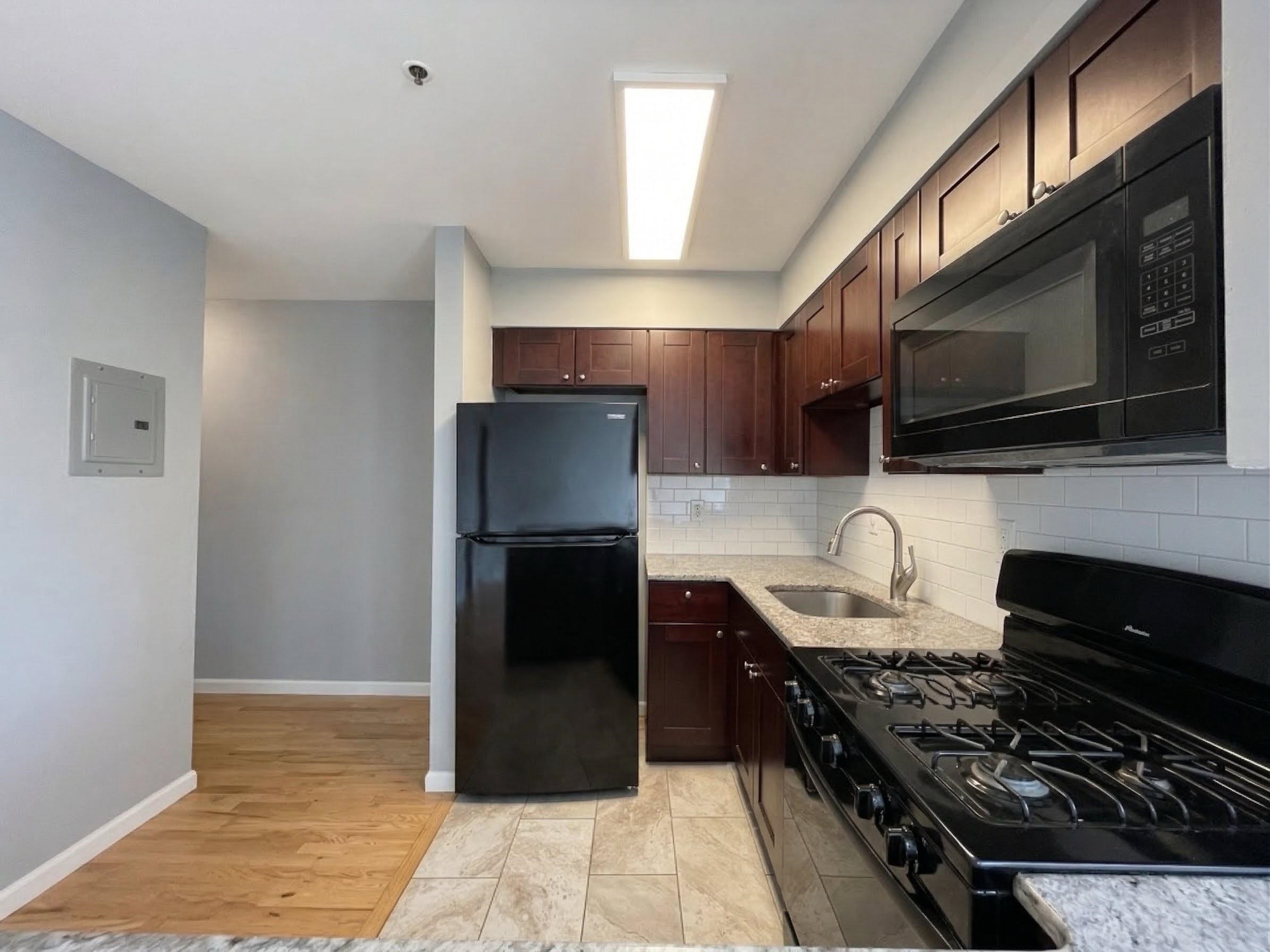 420 6th Street, Unit 3 Union City, NJ 07087 - Photo 4 of 12 a kitchen with stainless steel appliances a stove a sink and a microwave