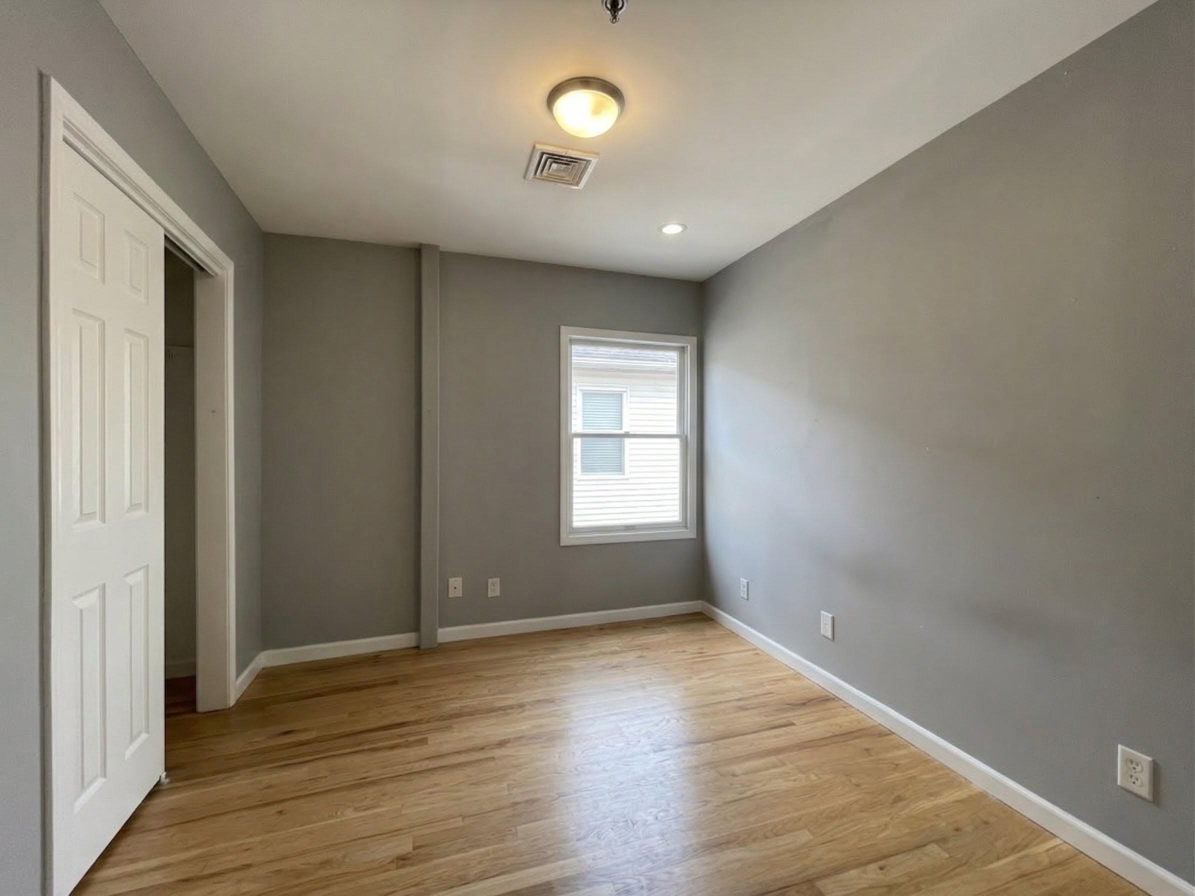 420 6th Street, Unit 3 Union City, NJ 07087 - Photo 7 of 12 wooden floor in an empty room with a window
