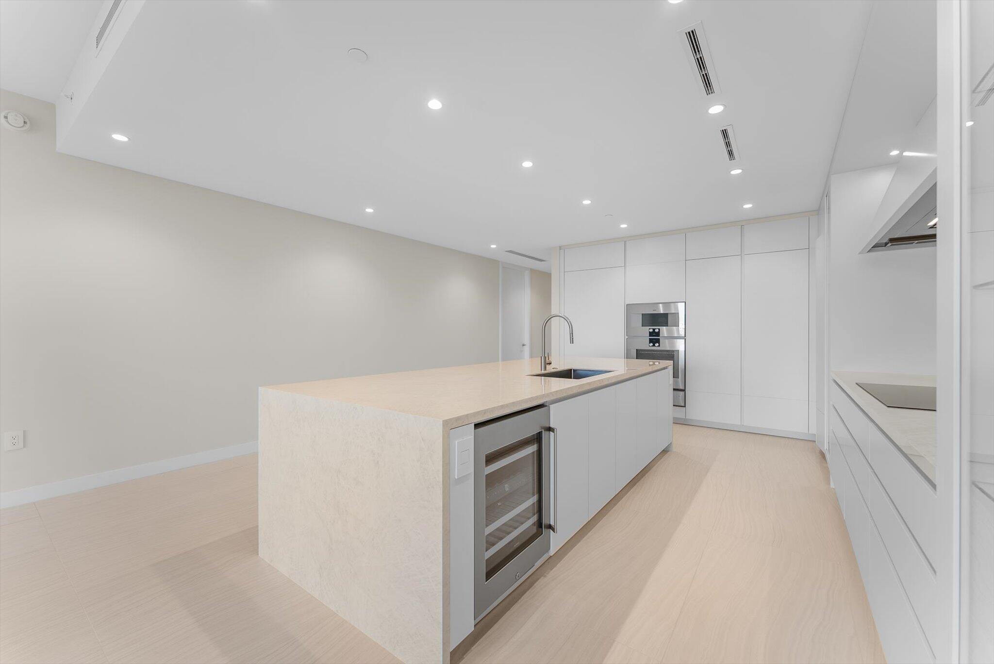 220 Southeast Mizner Boulevard, Unit 609 Boca Raton, FL 33432 - Photo 12 of 63 a large kitchen with a large counter top a sink stainless steel appliances and cabinets