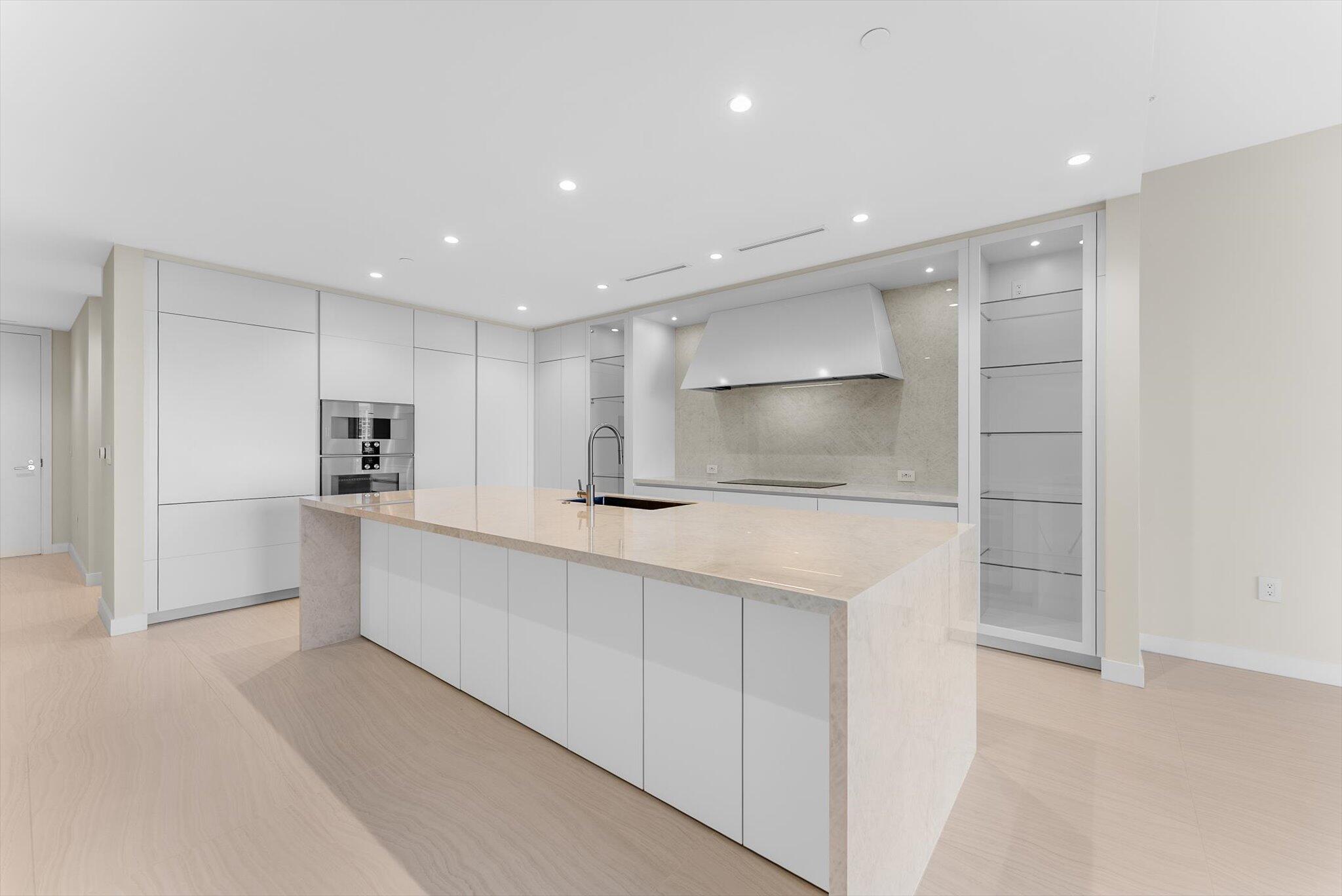 220 Southeast Mizner Boulevard, Unit 609 Boca Raton, FL 33432 - Photo 14 of 63 a large white kitchen with a refrigerator a sink and a stove