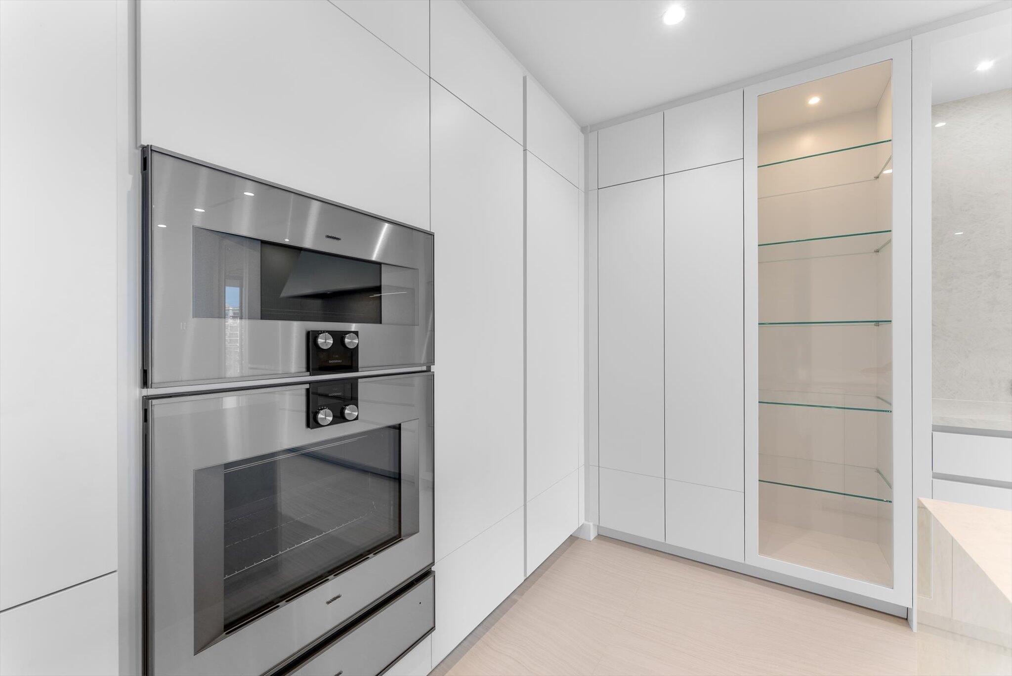 220 Southeast Mizner Boulevard, Unit 609 Boca Raton, FL 33432 - Photo 16 of 63 a kitchen with white cabinets and stainless steel appliances