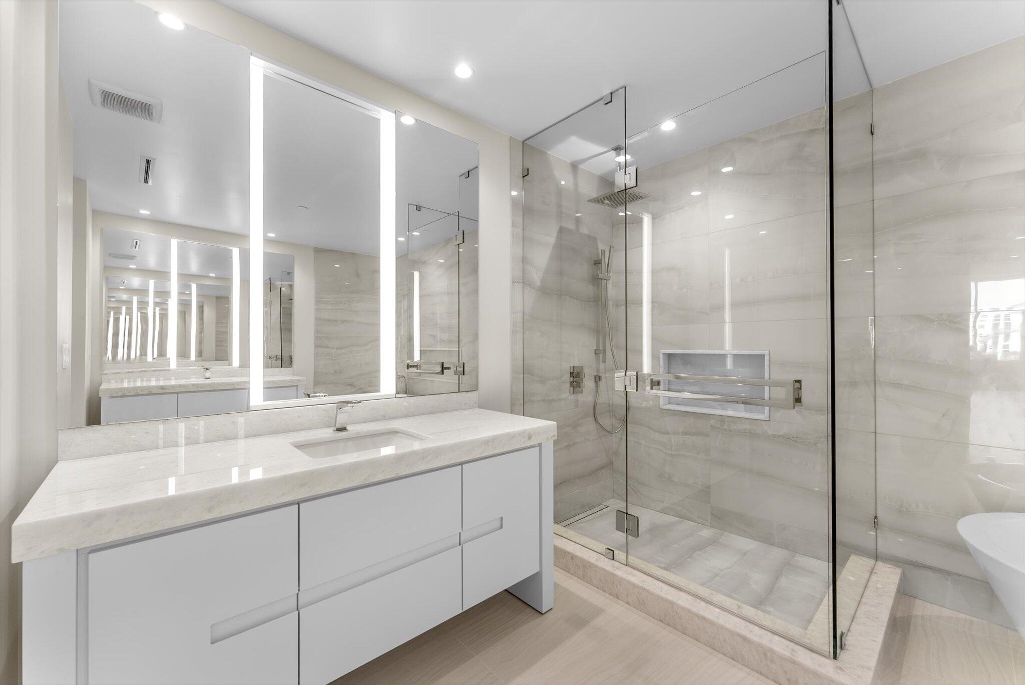 220 Southeast Mizner Boulevard, Unit 609 Boca Raton, FL 33432 - Photo 30 of 63 a bathroom with a shower sink vanity granite and a mirror