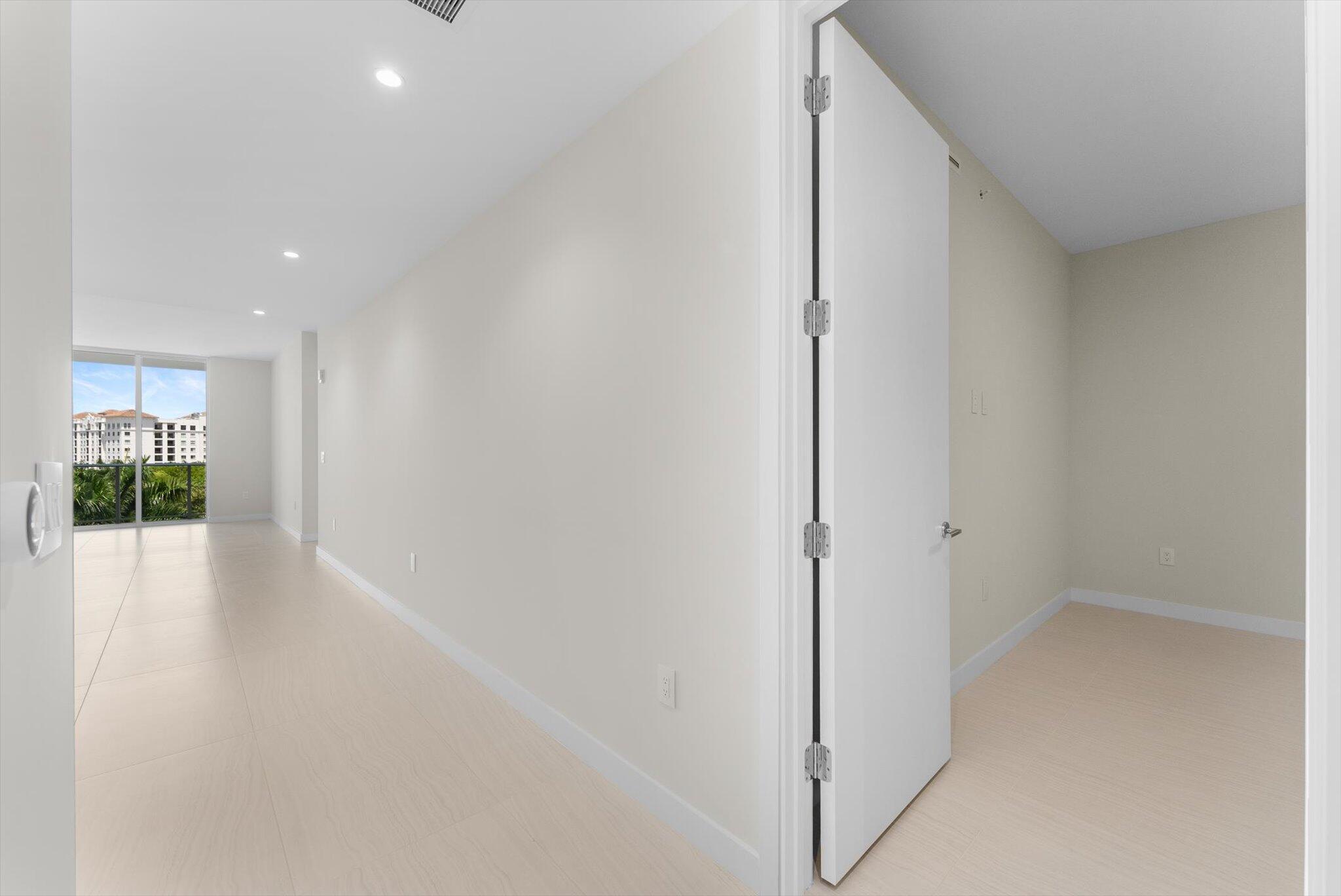 220 Southeast Mizner Boulevard, Unit 609 Boca Raton, FL 33432 - Photo 31 of 63 a view of a hallway with wooden floor and a living room