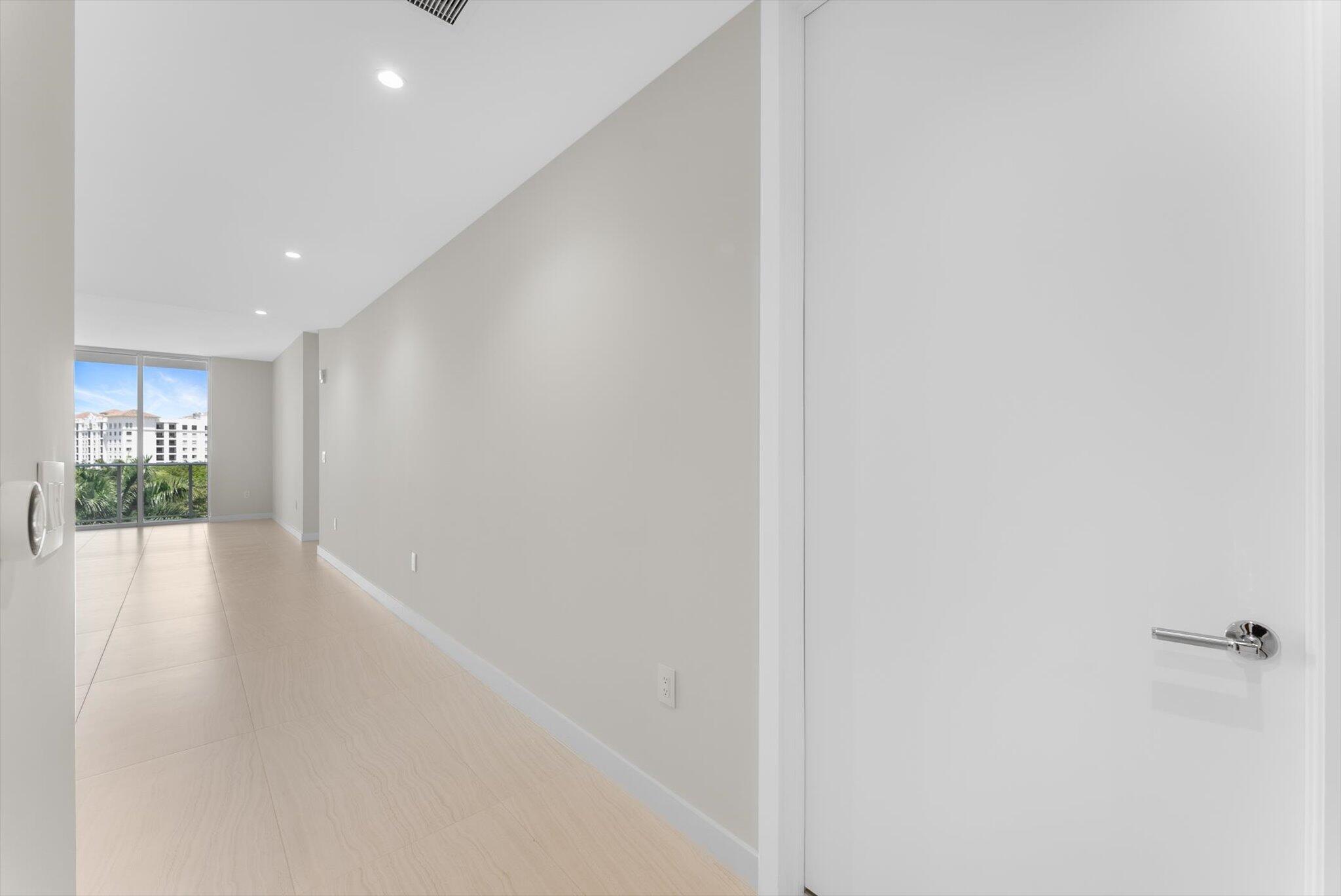 220 Southeast Mizner Boulevard, Unit 609 Boca Raton, FL 33432 - Photo 34 of 63 a view of a hallway with wooden floor and a living room