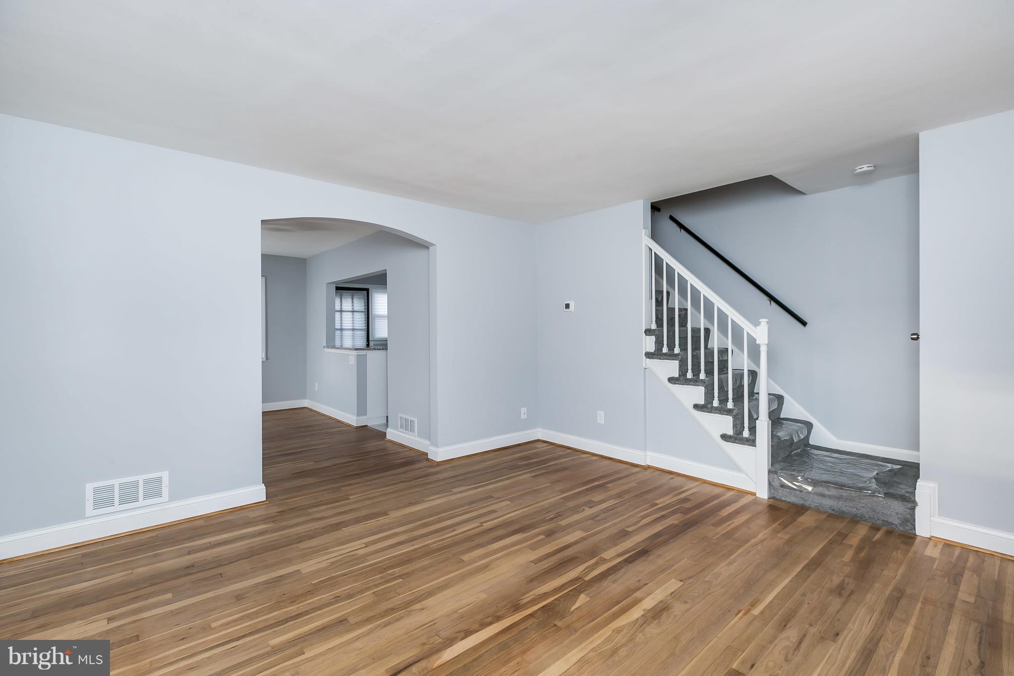 7808 Charlesmont Road Baltimore, MD 21222 - Photo 6 of 32 a view of an empty room with wooden floor and a window