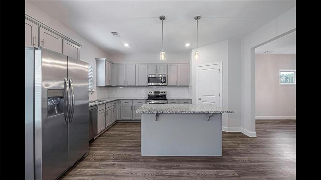 3792 Oak Rdg Drive, Unit HASTINGS Buford, GA 30519 - Photo 12 of 32 a kitchen with stainless steel appliances granite countertop a refrigerator a sink dishwasher a stove and white cabinets with wooden floor