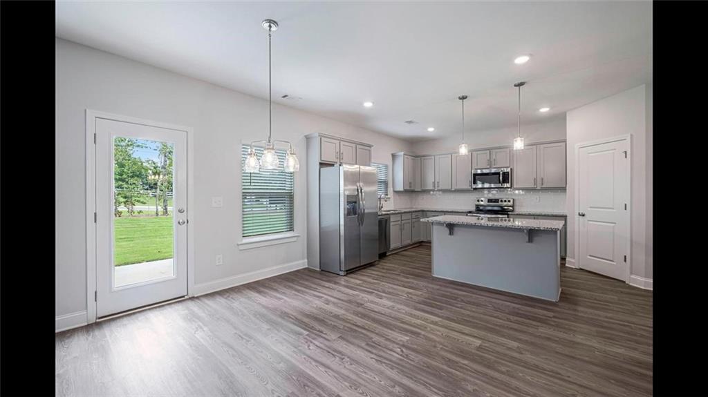 3792 Oak Rdg Drive, Unit HASTINGS Buford, GA 30519 - Photo 24 of 32 a kitchen with stainless steel appliances granite countertop a refrigerator a sink dishwasher a stove and a large window with wooden floor