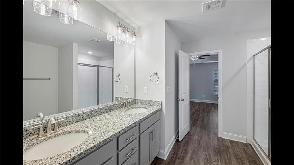 3792 Oak Rdg Drive, Unit HASTINGS Buford, GA 30519 - Photo 26 of 32 a bathroom with a granite countertop double vanity sink and mirror