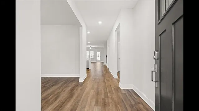 a view of a hallway with wooden floor