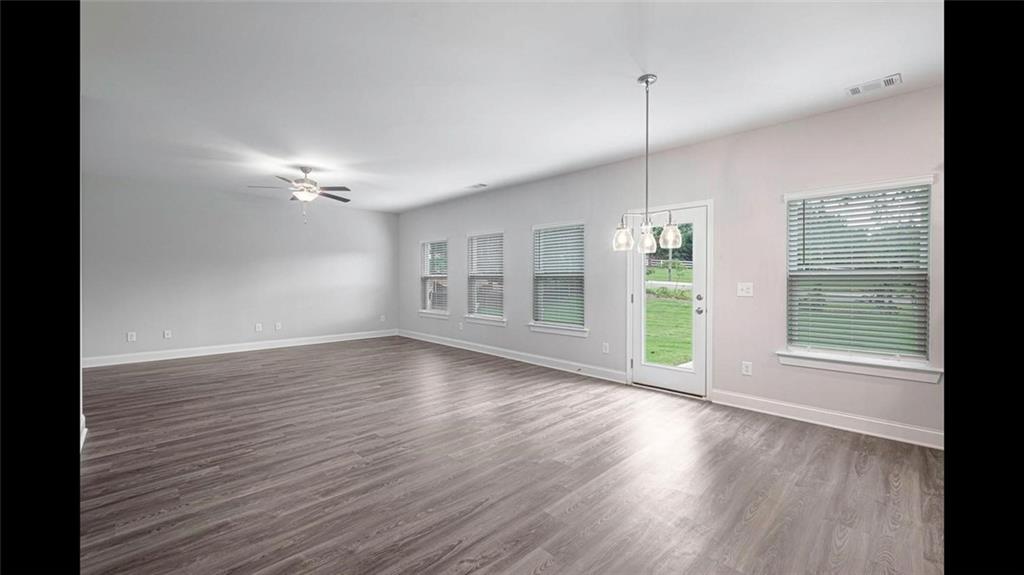 3792 Oak Rdg Drive, Unit HASTINGS Buford, GA 30519 - Photo 9 of 32 a view of an empty room with wooden floor and a window