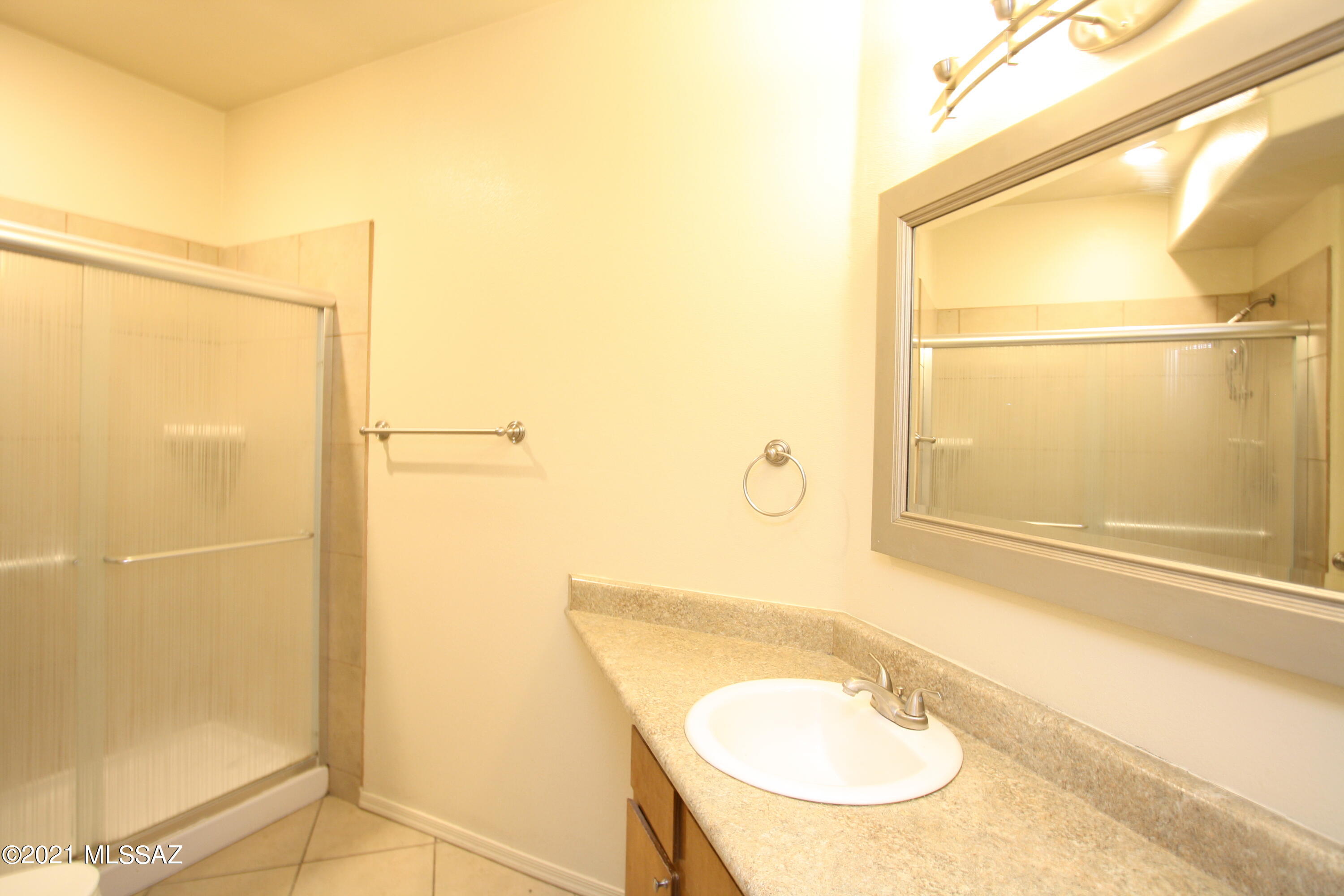 2550 East River Road, Unit 5104 Tucson, AZ 85718 - Photo 12 of 14 a bathroom with a sink mirror vanity and shower