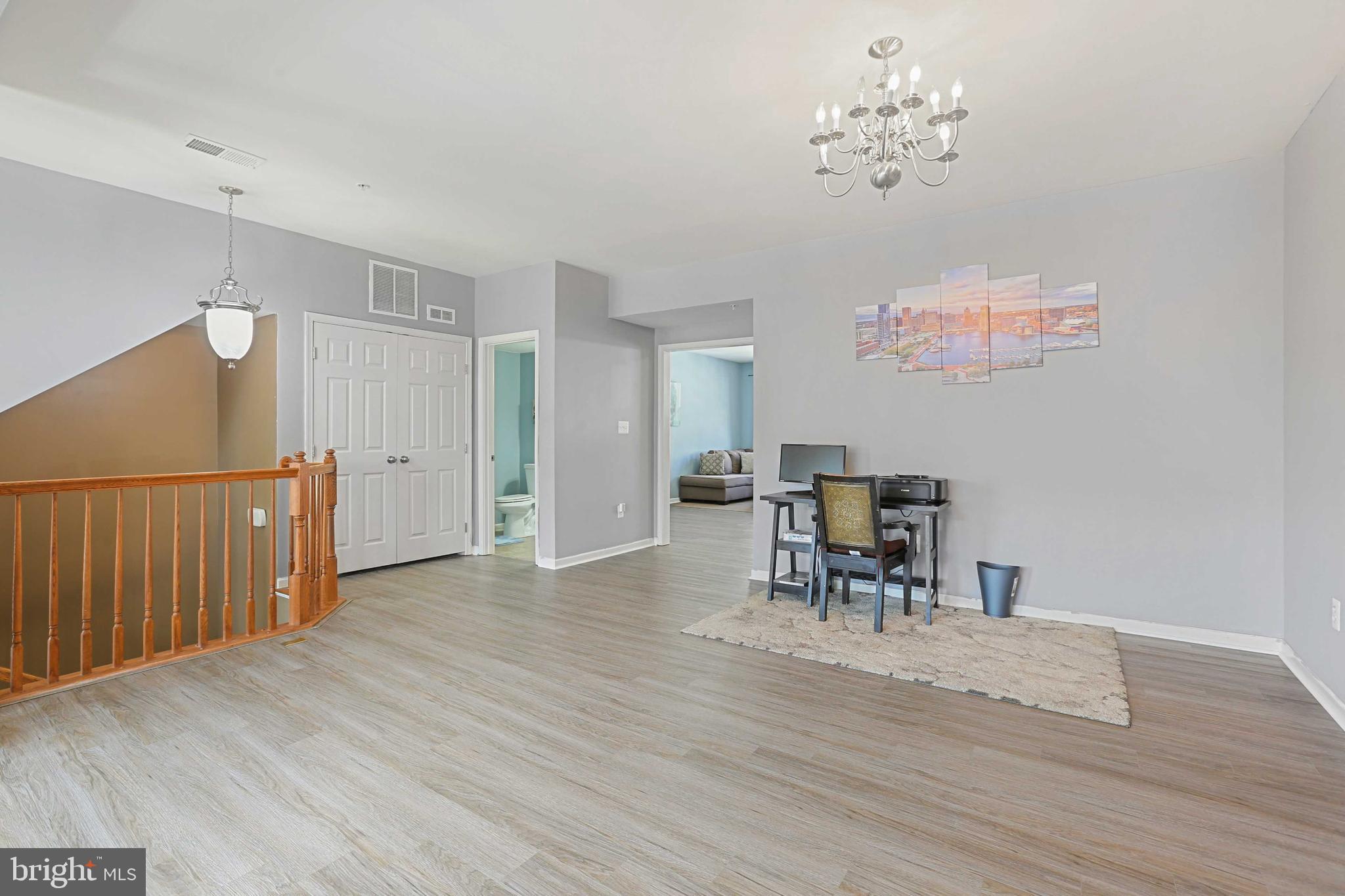 7209 Darby Downs, Unit 7209 Elkridge, MD 21075 - Photo 4 of 19 a dining room with furniture a chandelier and wooden floor