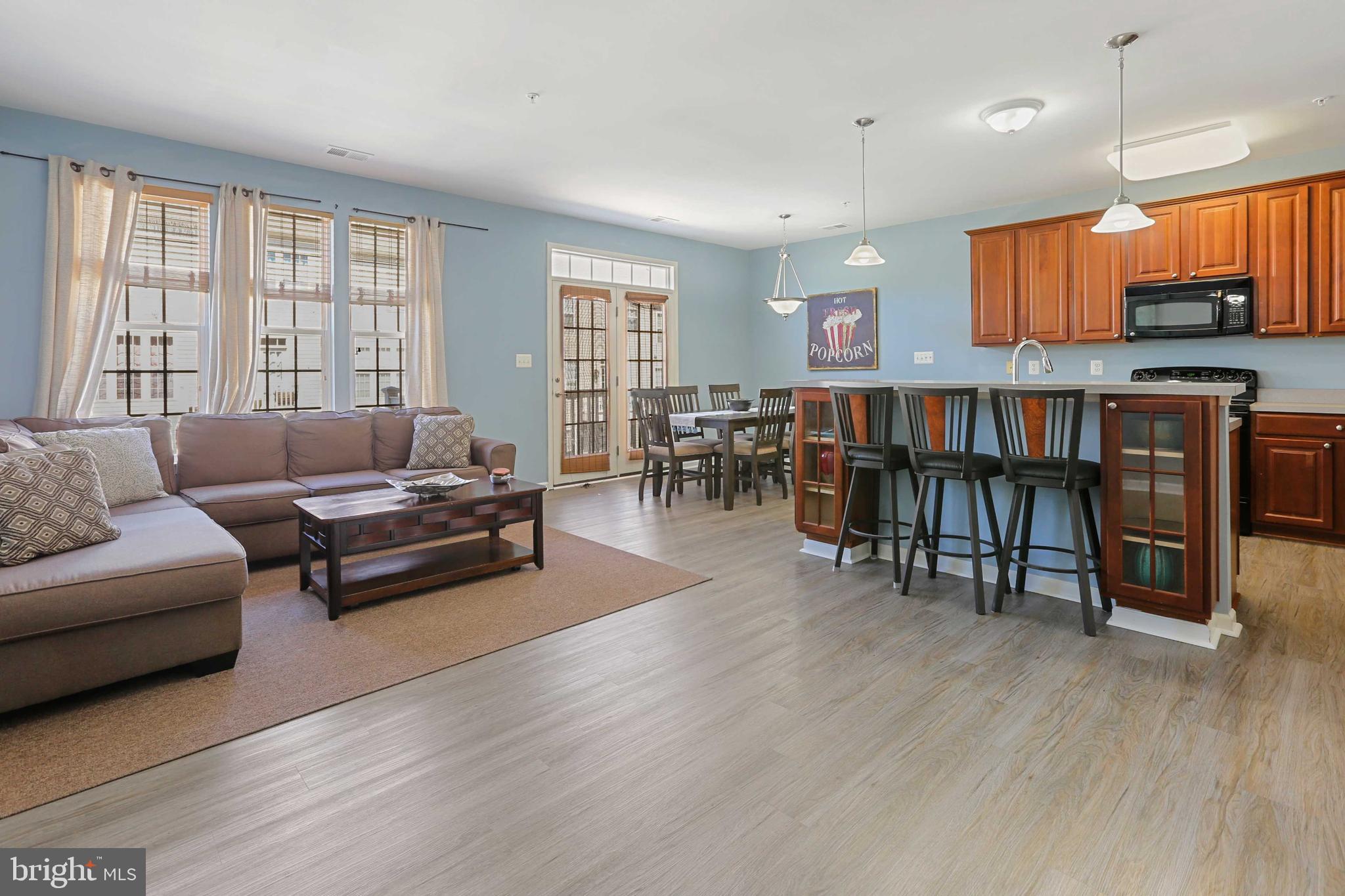 7209 Darby Downs, Unit 7209 Elkridge, MD 21075 - Photo 5 of 19 a living room with furniture wooden floor and a floor to ceiling window