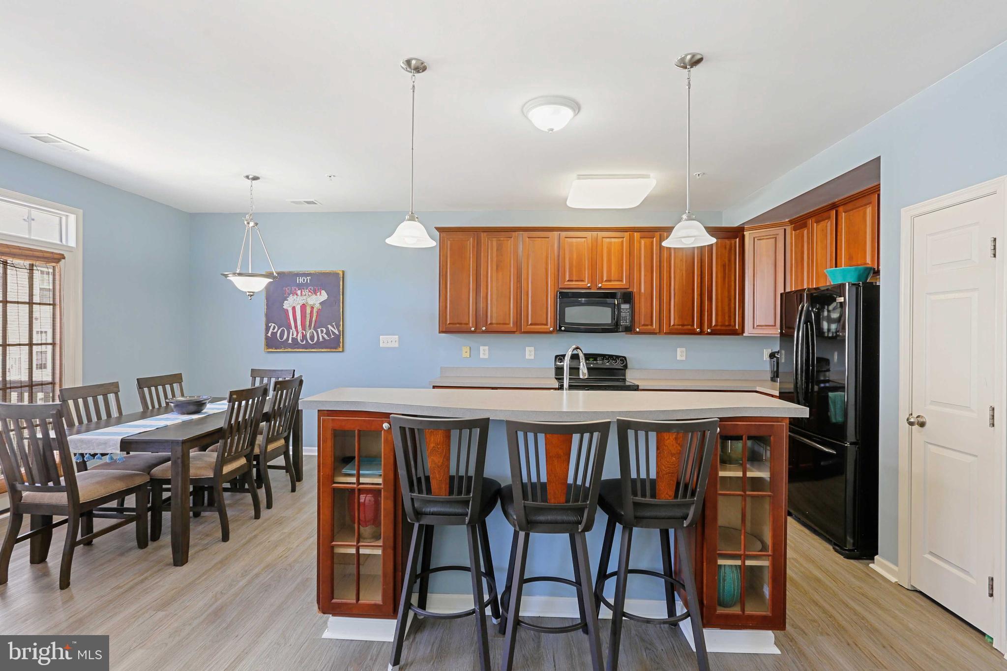 7209 Darby Downs, Unit 7209 Elkridge, MD 21075 - Photo 6 of 19 a kitchen with stainless steel appliances granite countertop a dining table chairs refrigerator and sink