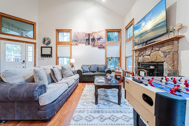 a living room with furniture a fireplace and a kitchen view