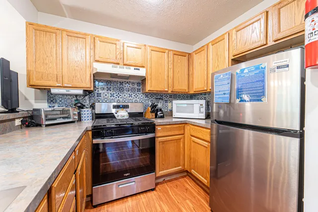 a kitchen with stainless steel appliances granite countertop a stove a sink and a microwave