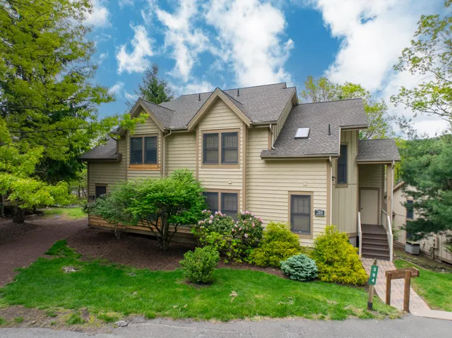 a front view of a house with a yard and potted plants