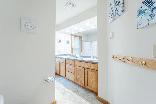 a bathroom with a sink double vanity granite tub shower and a mirror