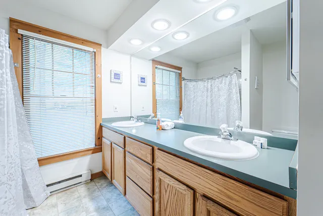 a bathroom with a granite countertop sink and a bathtub