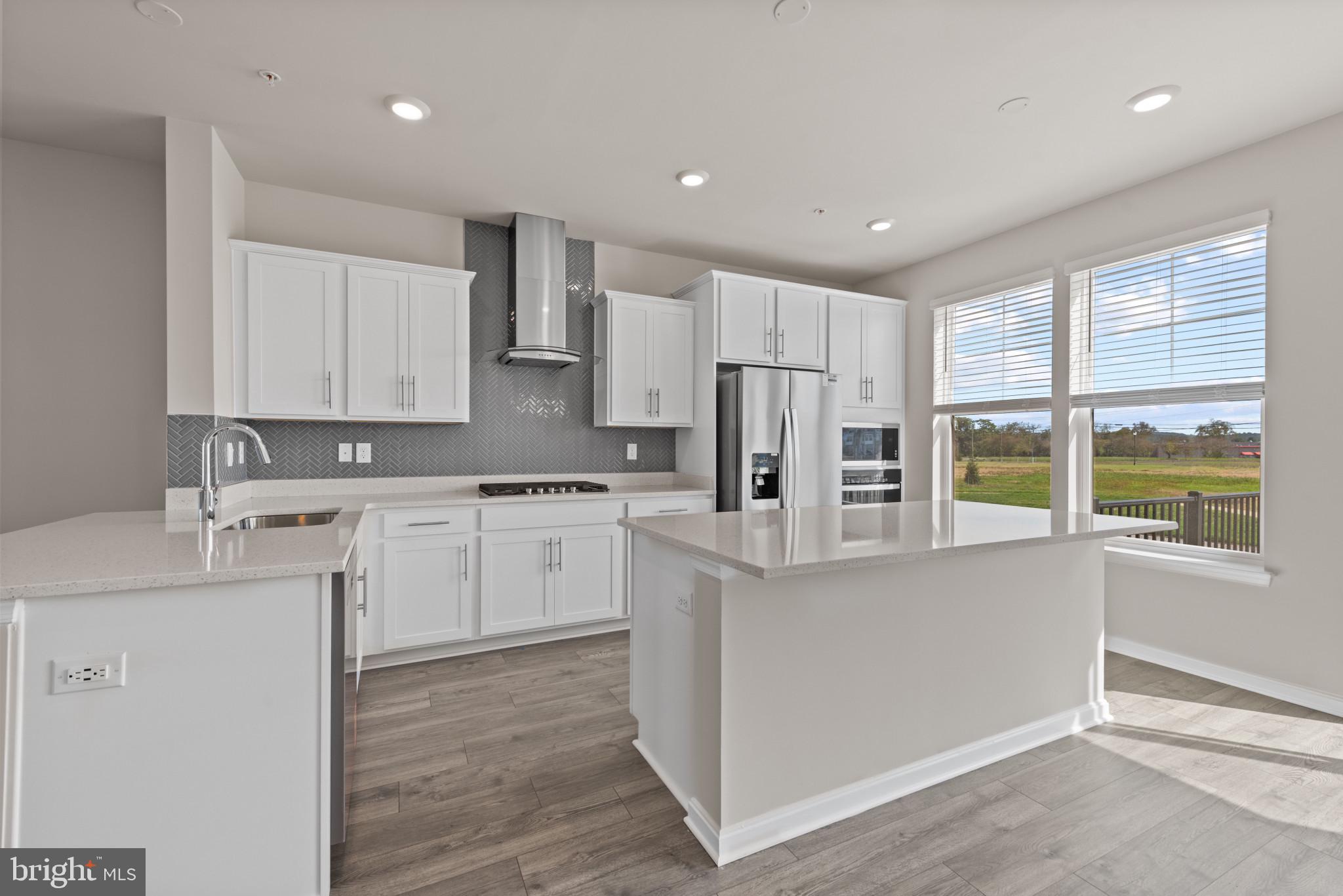 425 Ensemble Way Frederick, MD 21701 - Photo 13 of 37 a kitchen with white cabinets and white appliances