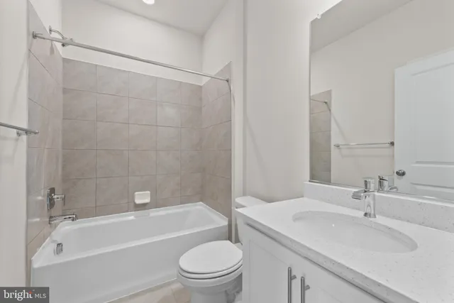a bathroom with a granite countertop toilet a sink and a bathtub