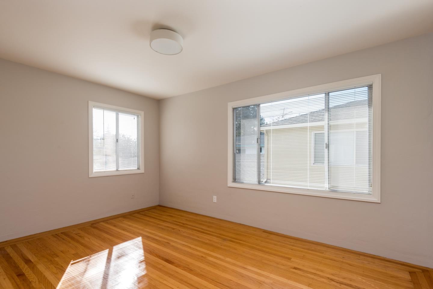 882 Middle Avenue Menlo Park, CA 94025 - Photo 7 of 22 a view of an empty room with wooden floor and a window