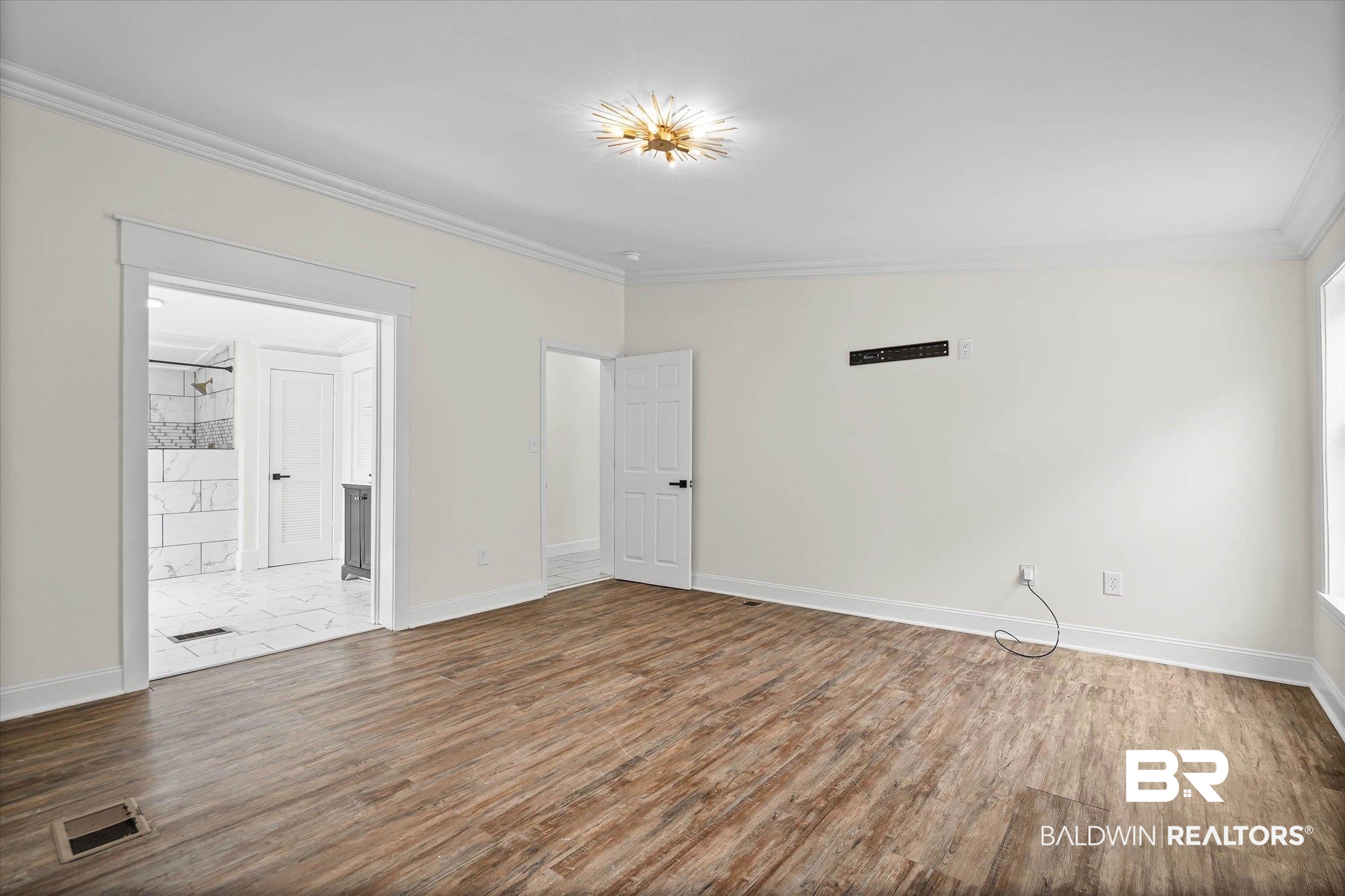 9230 McLeod Road Mobile, AL 36695 - Photo 11 of 20 Spacious room featuring wood-finish flooring, white walls, and a decorative ceiling light fixture