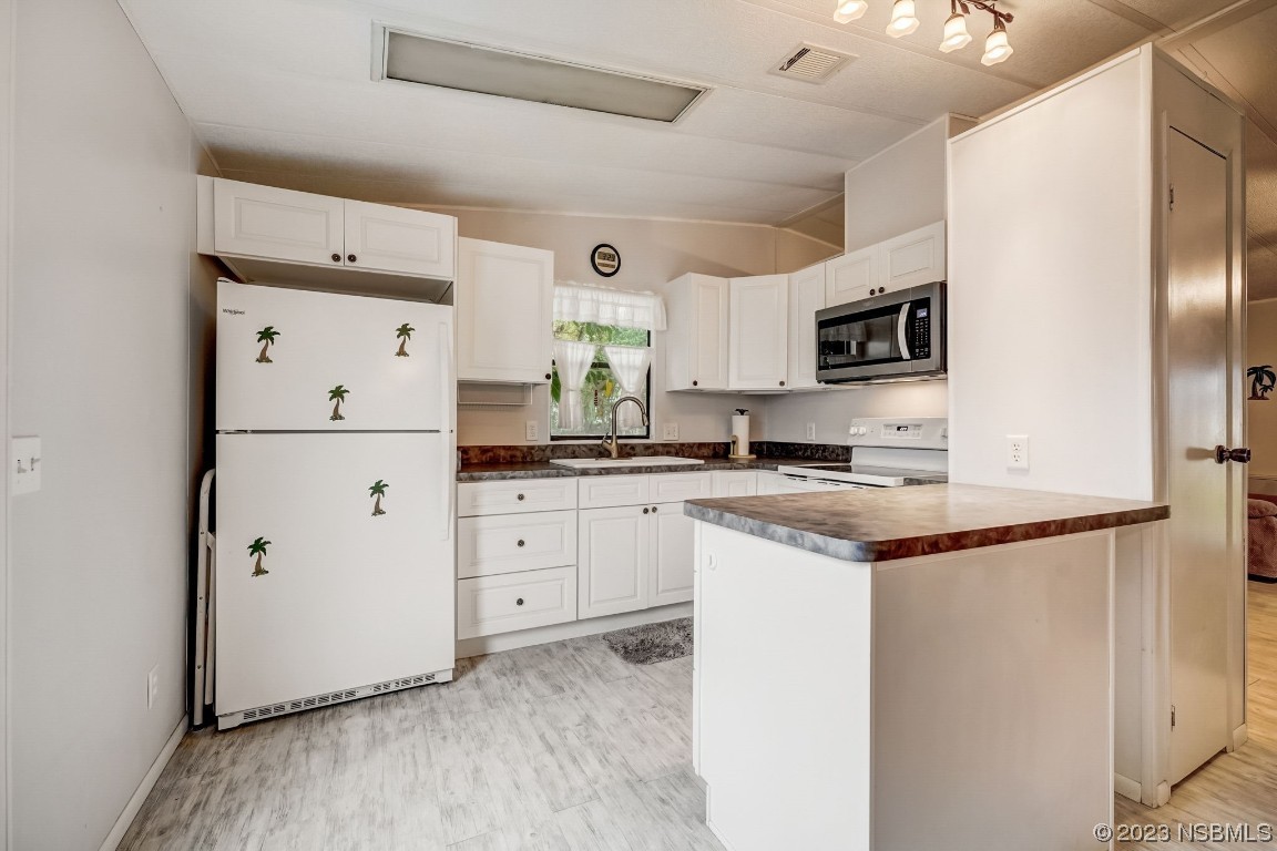 2201 South Ridgewood Avenue, Unit 21 Edgewater, FL 32141 - Photo 12 of 38 a kitchen with stainless steel appliances a refrigerator sink and microwave