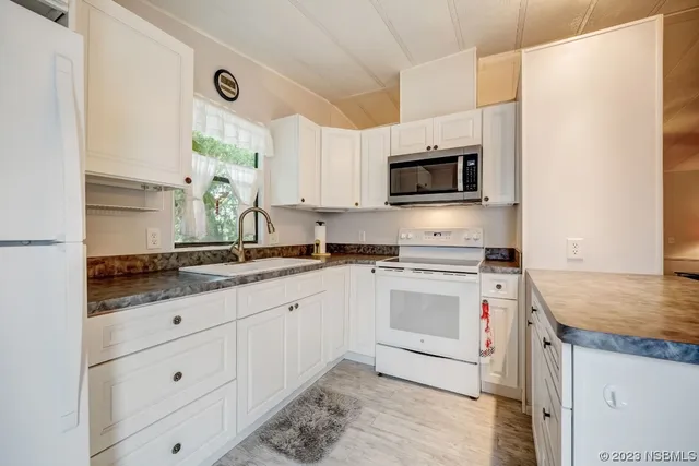 a kitchen with granite countertop a sink and a stove top oven