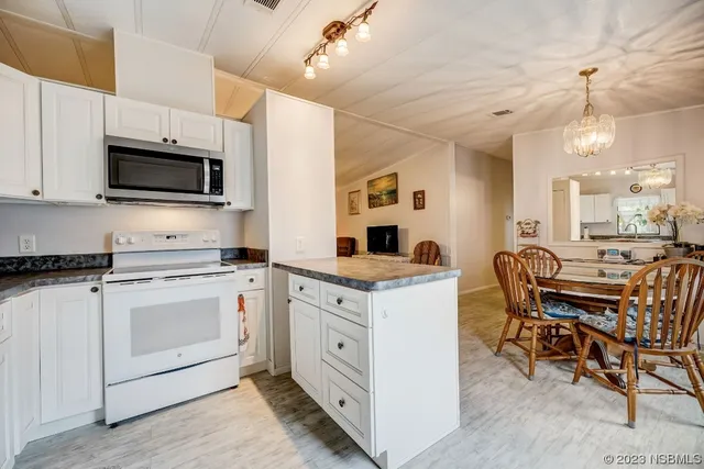 a kitchen with granite countertop white cabinets and stainless steel appliances