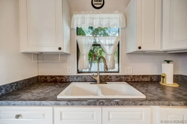 a kitchen with granite countertop a sink a window and counter space