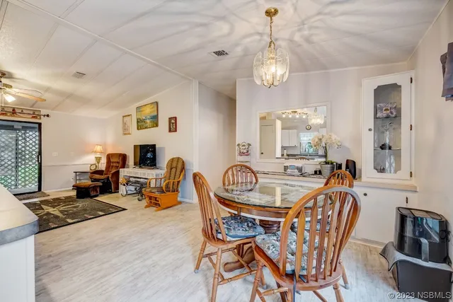 a dining room with furniture a chandelier and window
