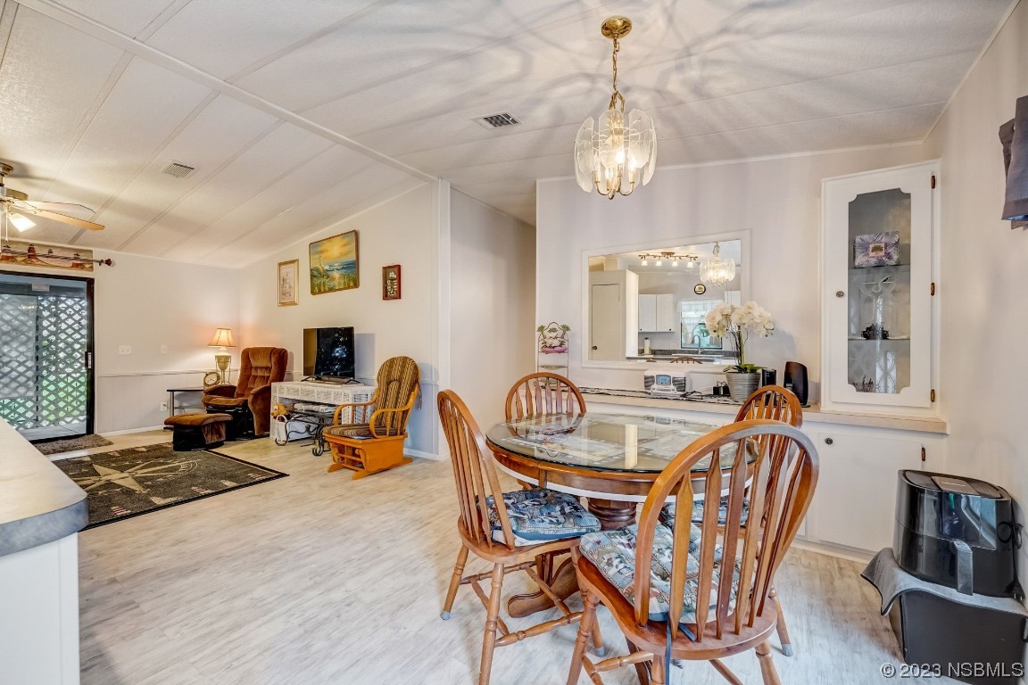 2201 South Ridgewood Avenue, Unit 21 Edgewater, FL 32141 - Photo 16 of 38 a dining room with furniture a chandelier and window