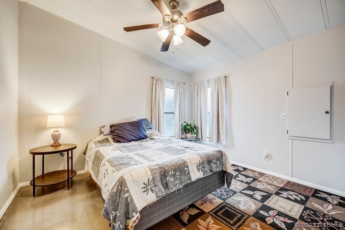 2201 South Ridgewood Avenue, Unit 21 Edgewater, FL 32141 - Photo 19 of 38 a bedroom with a bed and a chandelier