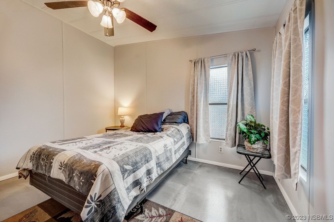 2201 South Ridgewood Avenue, Unit 21 Edgewater, FL 32141 - Photo 20 of 38 a bedroom with a bed and potted plant next to a window