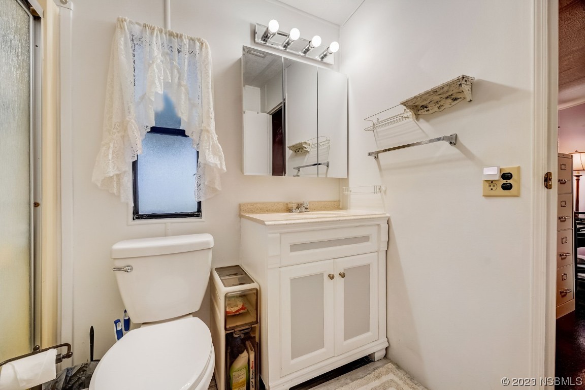 2201 South Ridgewood Avenue, Unit 21 Edgewater, FL 32141 - Photo 26 of 38 a bathroom with a toilet sink and mirror