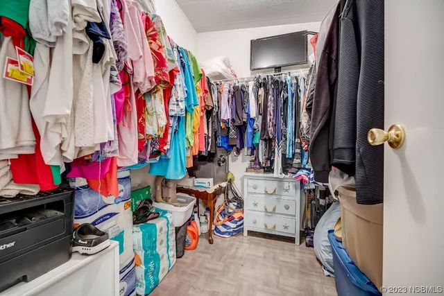 a view of walk in closet with clothes and shoes