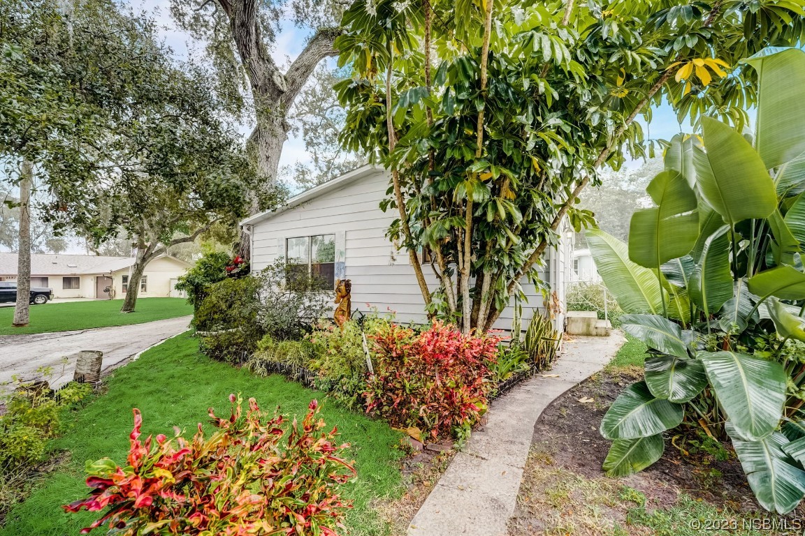 2201 South Ridgewood Avenue, Unit 21 Edgewater, FL 32141 - Photo 28 of 38 a front view of a house with a yard and fountain