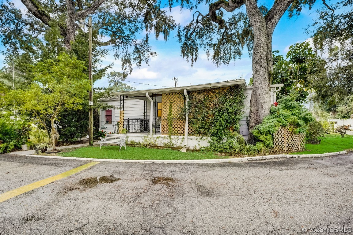 2201 South Ridgewood Avenue, Unit 21 Edgewater, FL 32141 - Photo 3 of 38 a front view of a house with a yard and potted plants