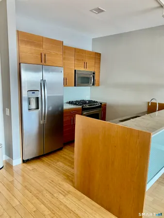 a kitchen with stainless steel appliances a refrigerator a stove a sink and a refrigerator