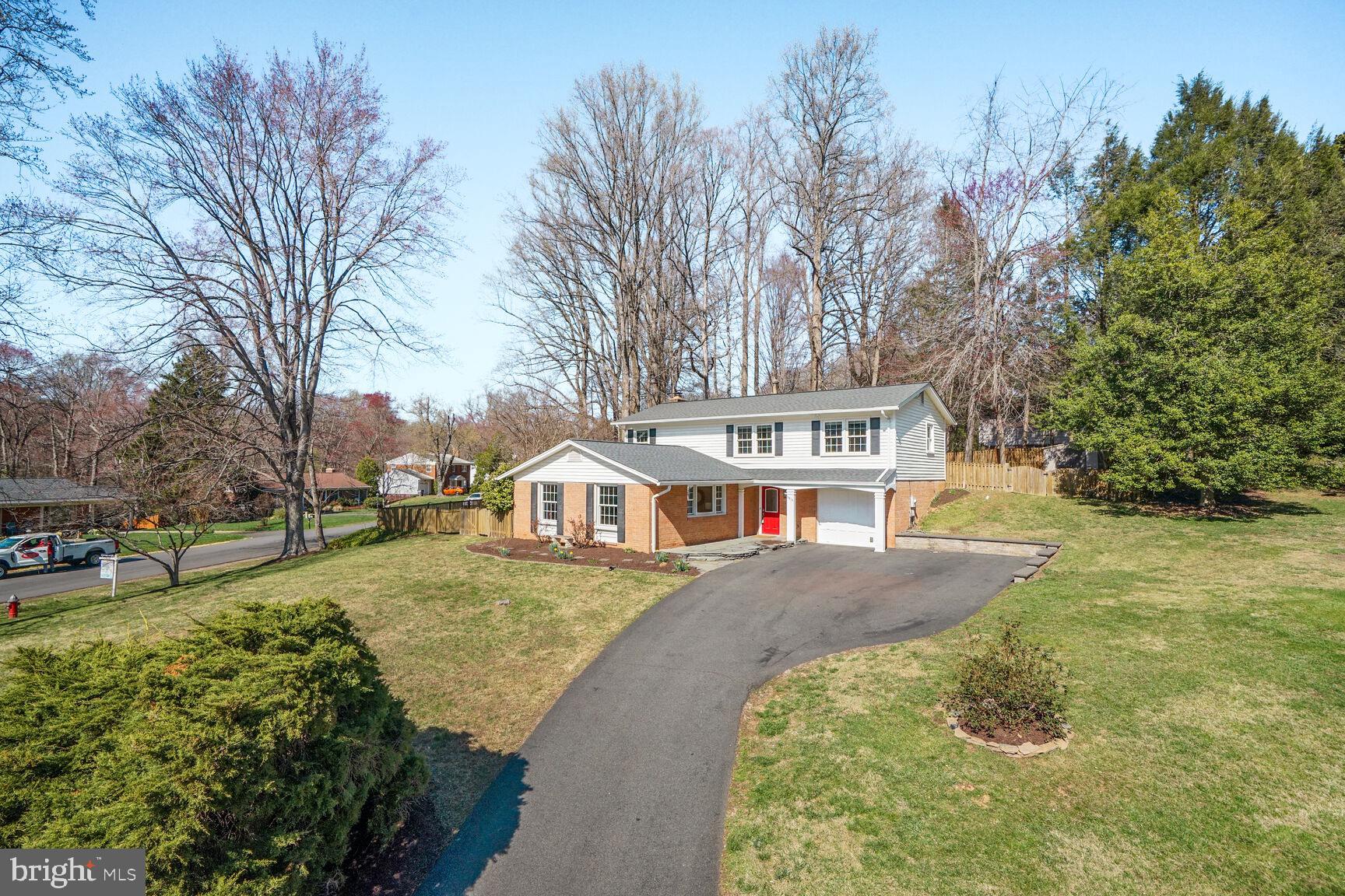 a front view of a house with a yard and trees