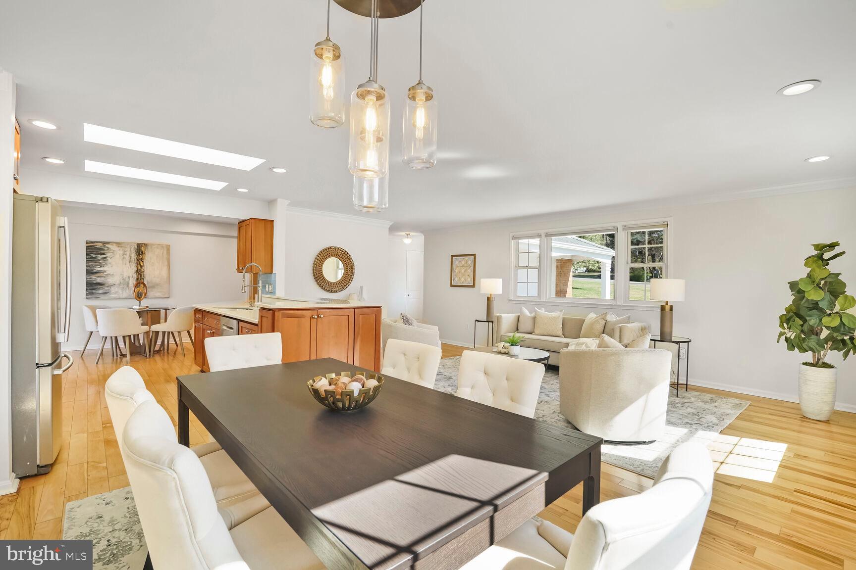 8618 Crestview Drive Fairfax, VA 22031 - Photo 12 of 33 a view of a dining room and livingroom with furniture wooden floor a rug a potted plant and a chandelier