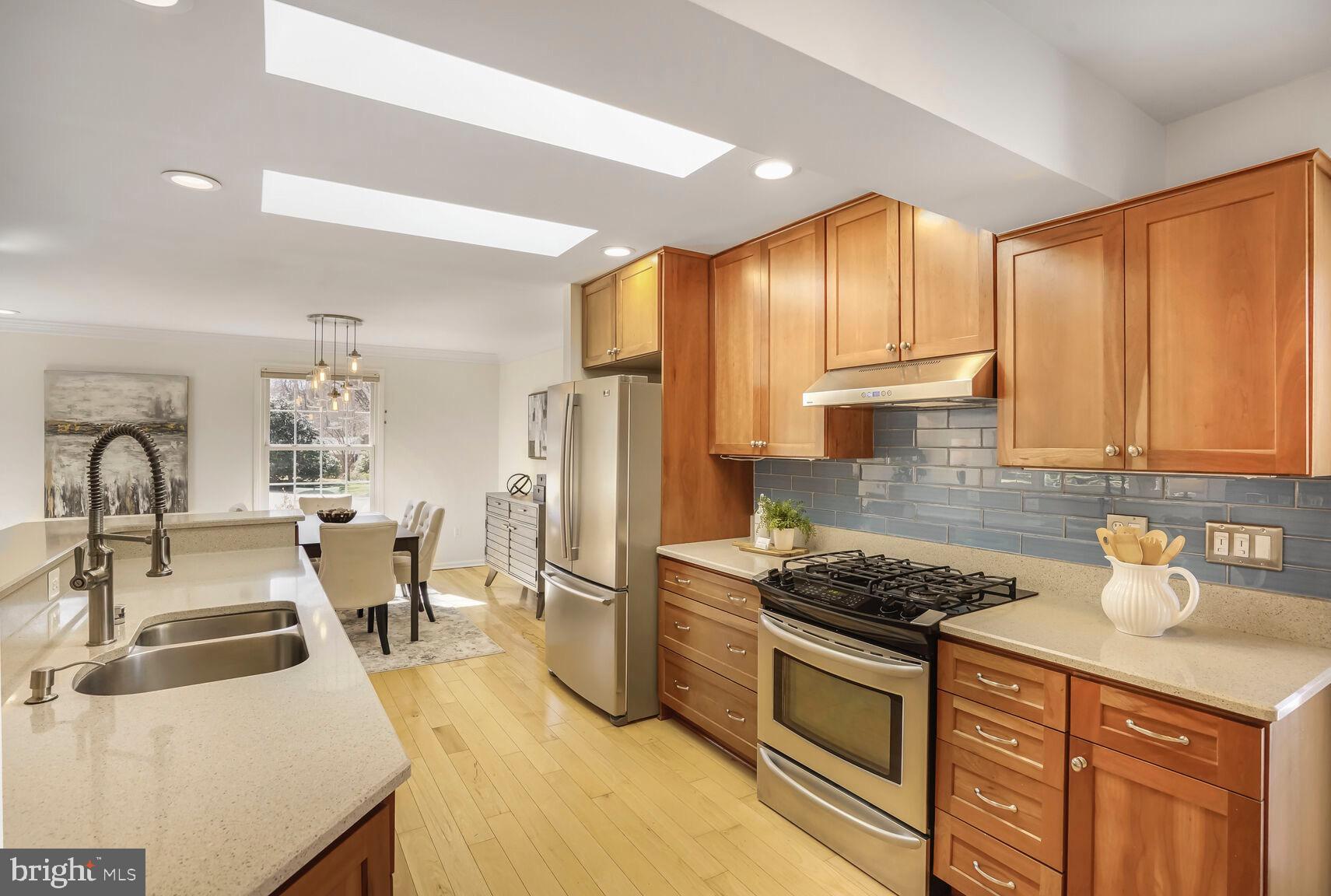 8618 Crestview Drive Fairfax, VA 22031 - Photo 15 of 33 a kitchen with kitchen island granite countertop a sink appliances cabinets and a counter top space