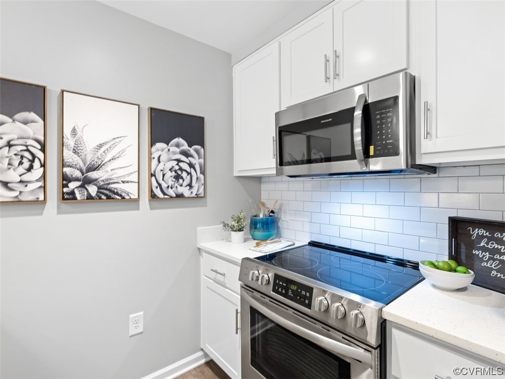 1504 Ewing Park Loop, Unit 201 Midlothian, VA 23113 - Photo 2 of 20 a kitchen with stainless steel appliances a stove a microwave and cabinets