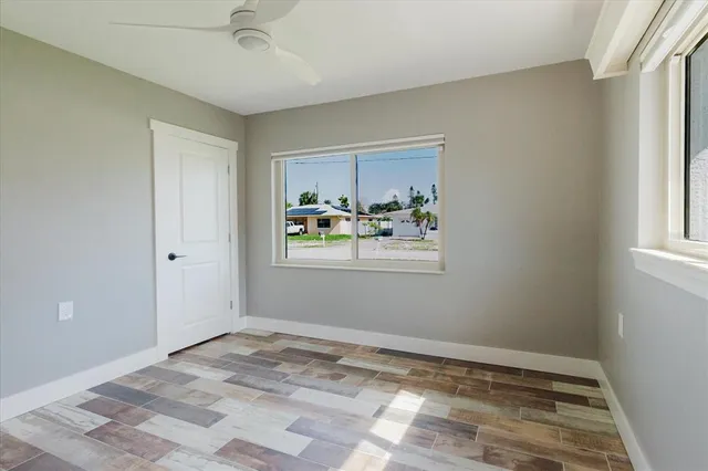 a view of empty room with window and wooden floor