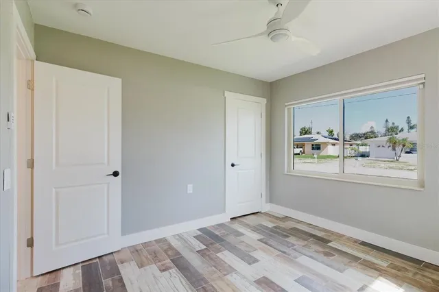 a view of a bedroom with wooden floor and windows