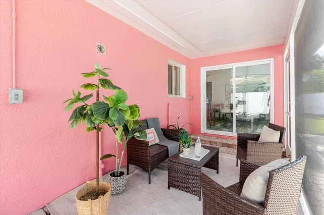 a living room with furniture potted plant and a floor to ceiling window