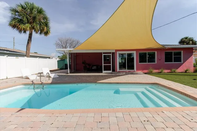 a view of house with swimming pool outdoor seating