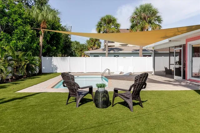 a view of a patio with table and chairs with wooden floor and fence